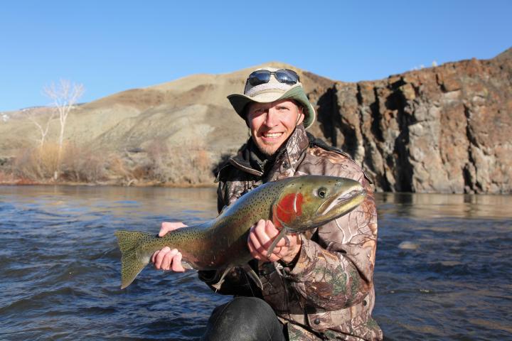 a man holding a fish in the water